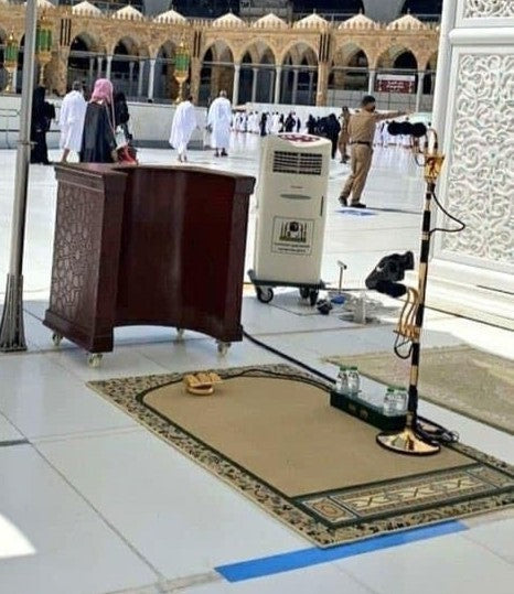 Beige Imam Al Haram prayer mat featuring intricate patterns, in front of the Kaabah in the Masjid al-Haram.